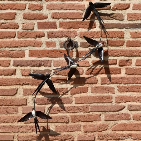 Cinq hirondelles en vol sur fixation murale