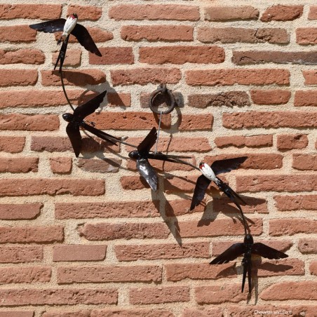 Cinq hirondelles en vol sur fixation murale